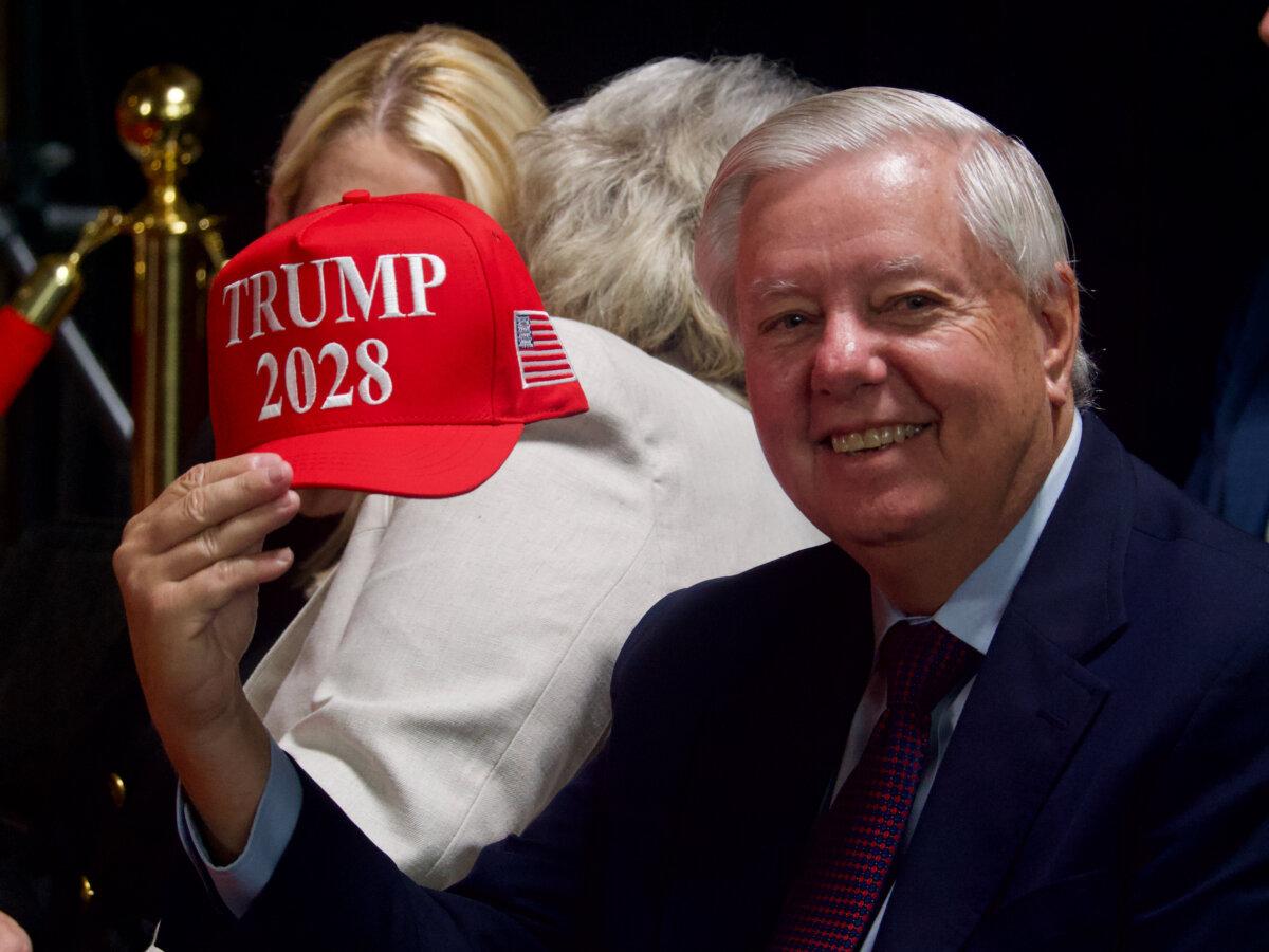 Sen. Lindsey Graham (R-S.C.) shows off a Trump 2028 ball cap before President Donald Trump took the stage at the John F. Kennedy Center for the Performing Arts in Washington on Aug. 13, 2025. (Travis Gillmore/The Epoch Times)