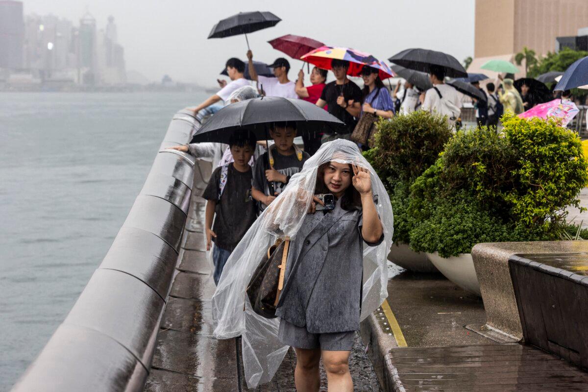 People use umbrellas to protect themselves from the rain in Hong Kong on Aug. 14, 2025, as Typhoon Podul weakens to a severe tropical storm. (Isaac Lawrence /AFP via Getty Images)
