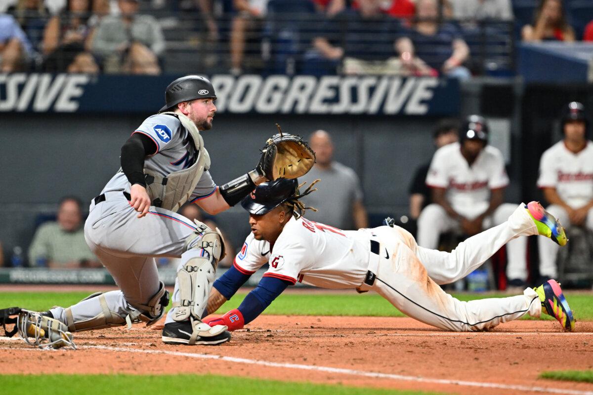 José Ramírez of the Cleveland Guardians scores as catcher Liam Hicks of the Miami Marlins waits for the throw during the seventh inning at Progressive Field in Cleveland, Ohio, on Aug. 14, 2025. (Jason Miller/Getty Images)