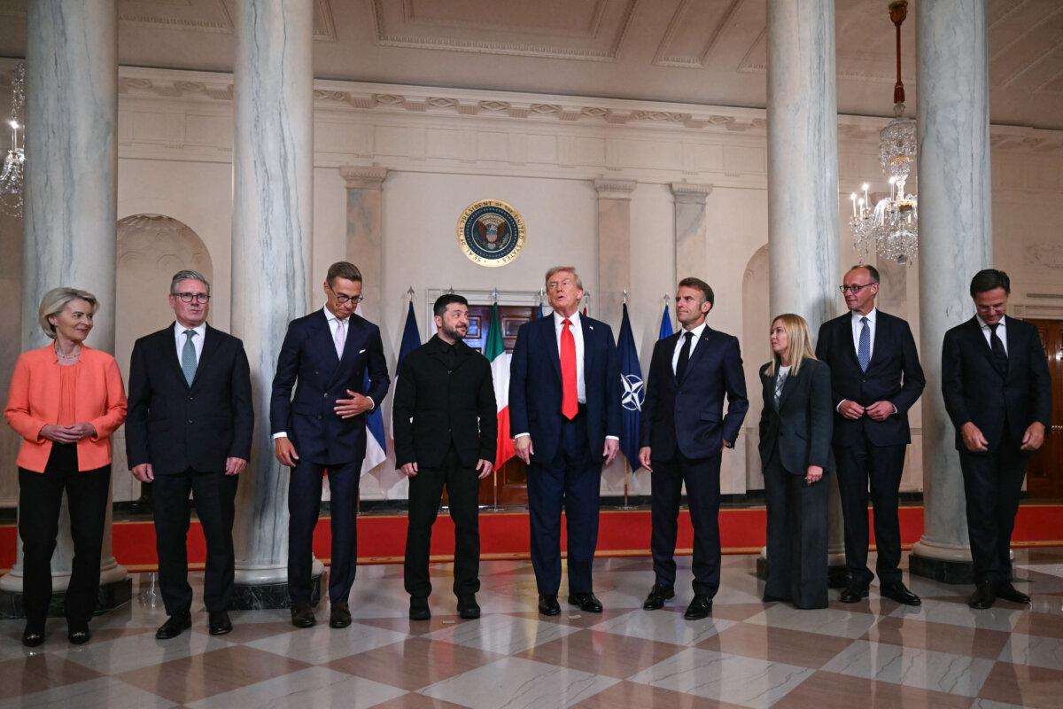 (L/R) European Commission President Ursula von der Leyen, British Prime Minister Keir Starmer, Finnish President Alexander Stubb, Ukrainian President Volodymyr Zelensky, US President Donald Trump, French President Emmanuel Macron, Italian Prime Minister Giorgia Meloni, German Chancellor Friedrich Merz and NATO Secretary-General Mark Rutte pose for a family photo in the Cross Hall of the White House in Washington, DC, on August 18, 2025. (Andrew Caballero-Reynolds/AFP via Getty Images)
