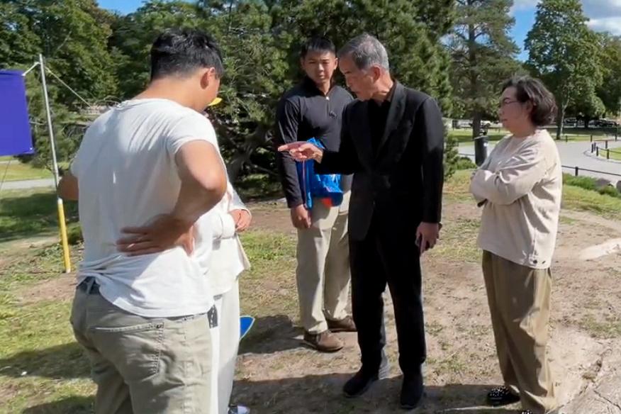 Leung Chun-ying, former Hong Kong chief executive and his wife, Regina Leung Tong Ching-yee, in a confrontational exchange with Falun Gong practitioners in Sibelius Park, Helsinki, on Aug. 13. (Courtesy of Helsinki Falun Gong practitioners)