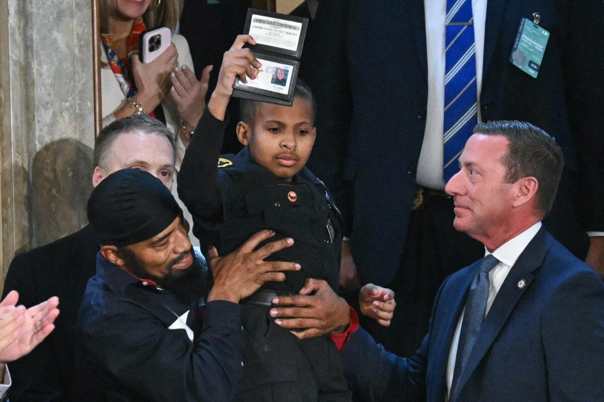 Devarjaye "DJ" Daniel is lifted up by his father, Theodis Daniel, after being given credentials from U.S. Secret Service Director Sean Curran after President Donald Trump made him an honorary member of the Secret Service during his address to a joint session of Congress at the U.S. Capitol in Washington on March 4, 2025. (Saul Loeb/AFP via Getty Images)