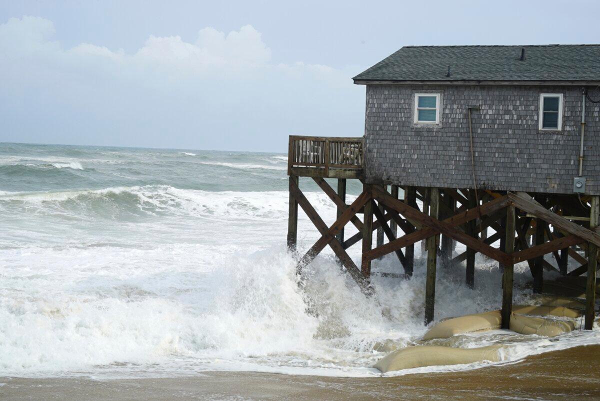 Waves from Hurricane Erin crash against the sandbagged pilings of a building in Buxton, N.C., on Aug. 20, 2025. (Allen G. Breed/AP Photo)