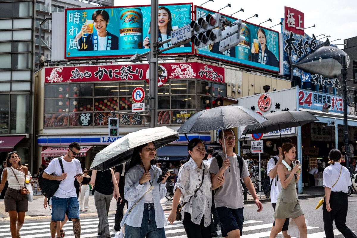 People walk across the street at the Tsukiji Outer Market in Tokyo on Aug. 22, 2025. (Philip Fong /AFP via Getty Images)