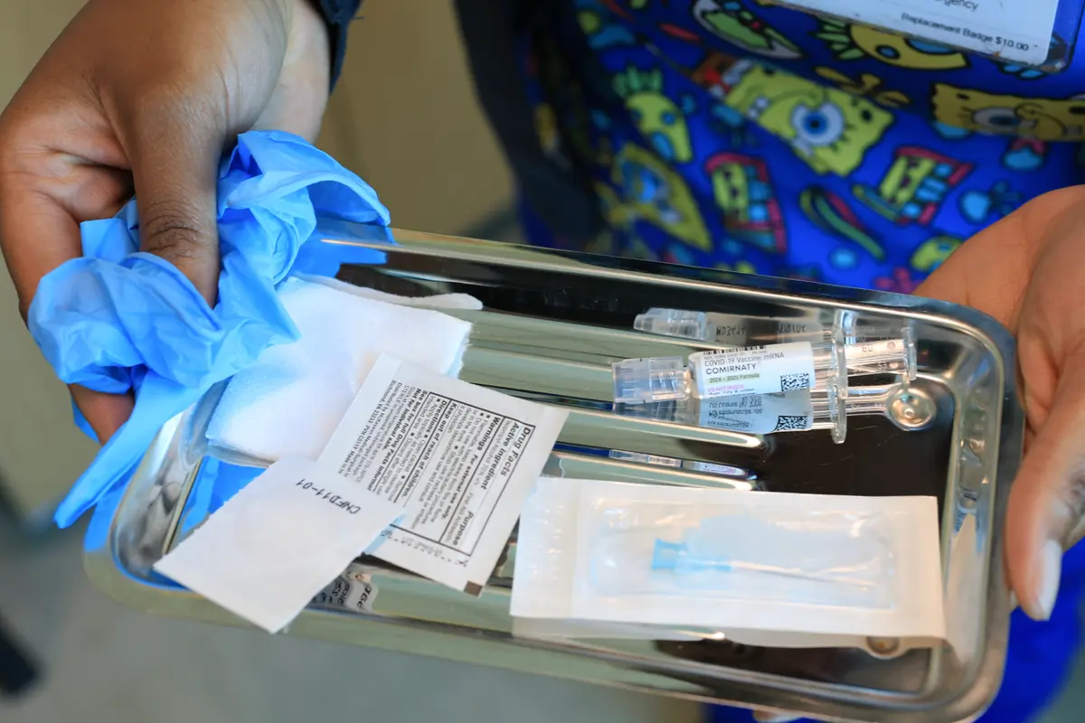 A nurse carries a tray with a Pfizer-BioNTech COVID-19 vaccine at Borinquen Health Care Center in Miami on May 29, 2025. (Joe Raedle/Getty Images)