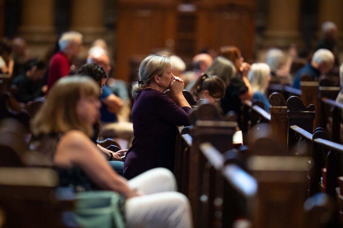 People pray at the Cathedral of Saint Paul, in the aftermath of the Annunciation Catholic School shooting, in Saint Paul, Minn., on Aug. 28, 2025. (Madalina Kilroy/The Epoch Times)
