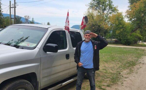 UOF supporter Ron Wilkison salutes in front of his truck at Universal Ostrich Farms in Edgewood, B.C. on Aug. 27, 2025. (Paul Rowan Brian/The Epoch Times).