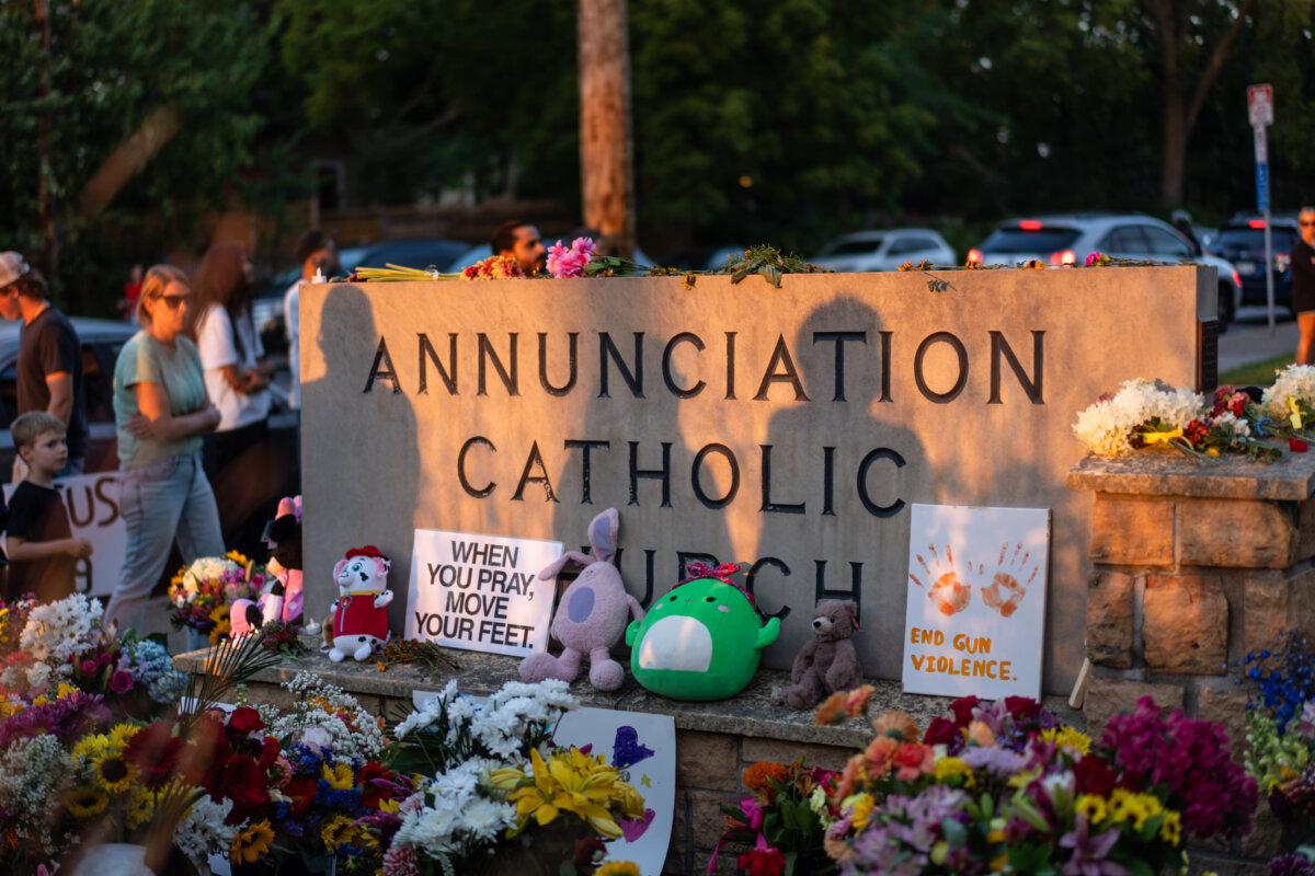 People leave flowers as they mourn in the aftermath of the Annunciation Catholic School shooting in Minneapolis on Aug. 28, 2025. (Madalina Kilroy/The Epoch Times)