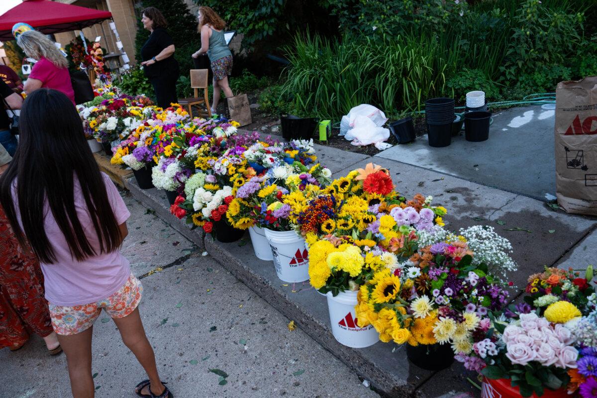 People leave flowers as they mourn in the aftermath of the Annunciation Catholic School shooting in Minneapolis on Aug. 28, 2025. (Madalina Kilroy/The Epoch Times)