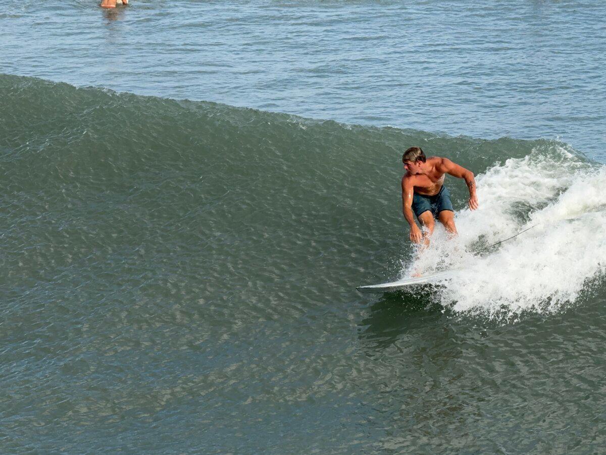 Owen Mohr surfs on Emerald Isle, N.C., on Aug. 21, 2025. (T.J. Muscaro/The Epoch Times)