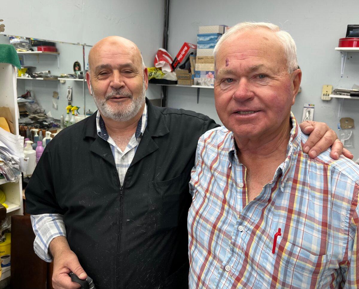 Alberta rancher Earl Scott (R) finishes with barber Mike at the Black Knight men's hair styling salon in Didsbury, Alberta, on Aug. 26, 2025. (Allan Stein/The Epoch Times)
