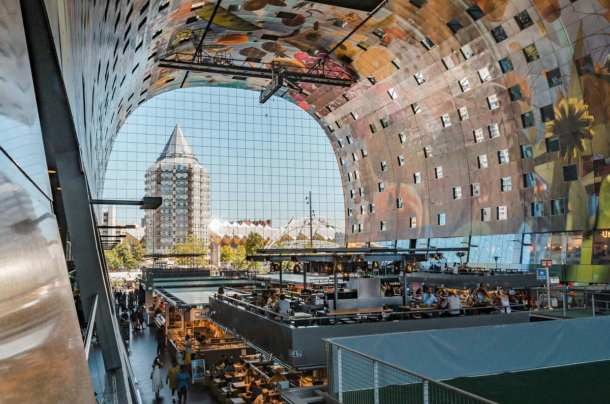 The interior ceiling of Market Hall is covered with a massive digital artwork called "Horn of Plenty," featuring colorful images of fruits, vegetables, and flowers. (Mike van den Bos/Unsplash)