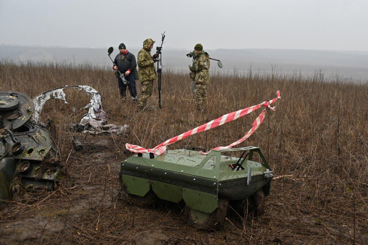 Deminers use metal detectors and a demining drone to search for mines in Derhachi, Ukraine, on March 19, 2024. (Sergey Bobok/AFP via Getty Images)