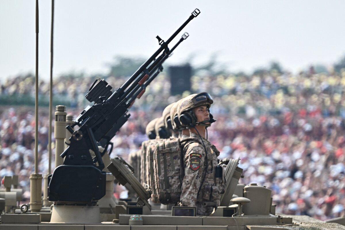 Officers are seen in the hatch of a Type 99 main battle tank as it rolls during a military parade marking the 80th anniversary of victory over Japan and the end of World War II, in Tiananmen Square in Beijing on Sept. 3, 2025. (Pedro Pardo/ AFP via Getty Images)