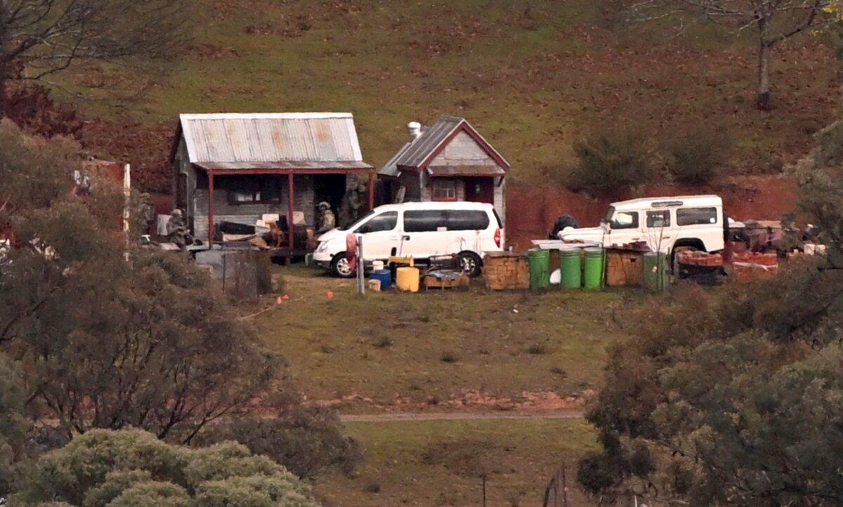 Armed police search a building on a property of interest during the search for a fugitive linked to the murder of two police officers in Porepunkah, Australia, on Aug. 29, 2025. (William West/ AFP)