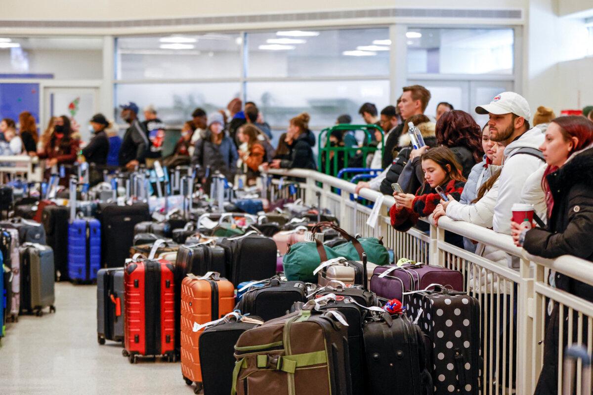 Travelers wait in a long line to check on their baggage from their canceled flights at Chicago Midway International Airport on Dec. 27, 2022. (Kamil Krzaczynski/Reuters)