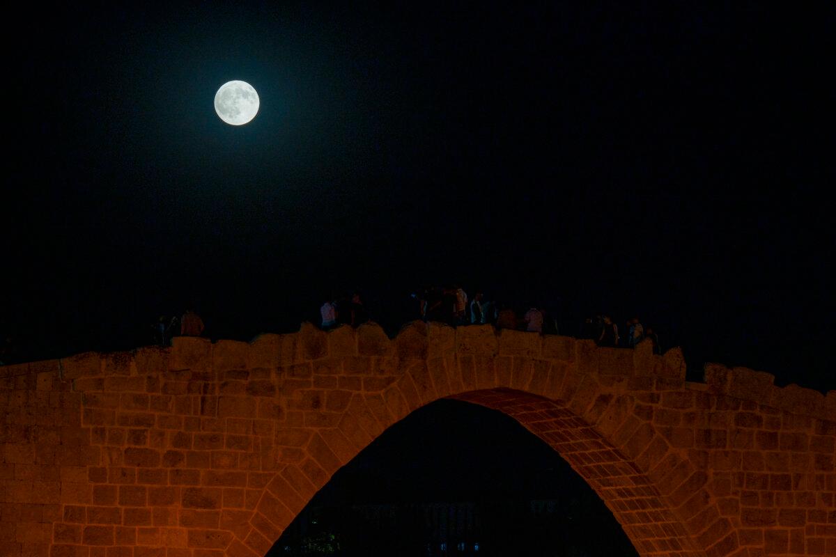Families gather at the historic Dalal Bridge in Zakho, Iraq, on Sept. 7, 2025, to watch a "blood moon" during a total lunar eclipse. (Mohammed Majid/Middle East Images/AFP via Getty Images)