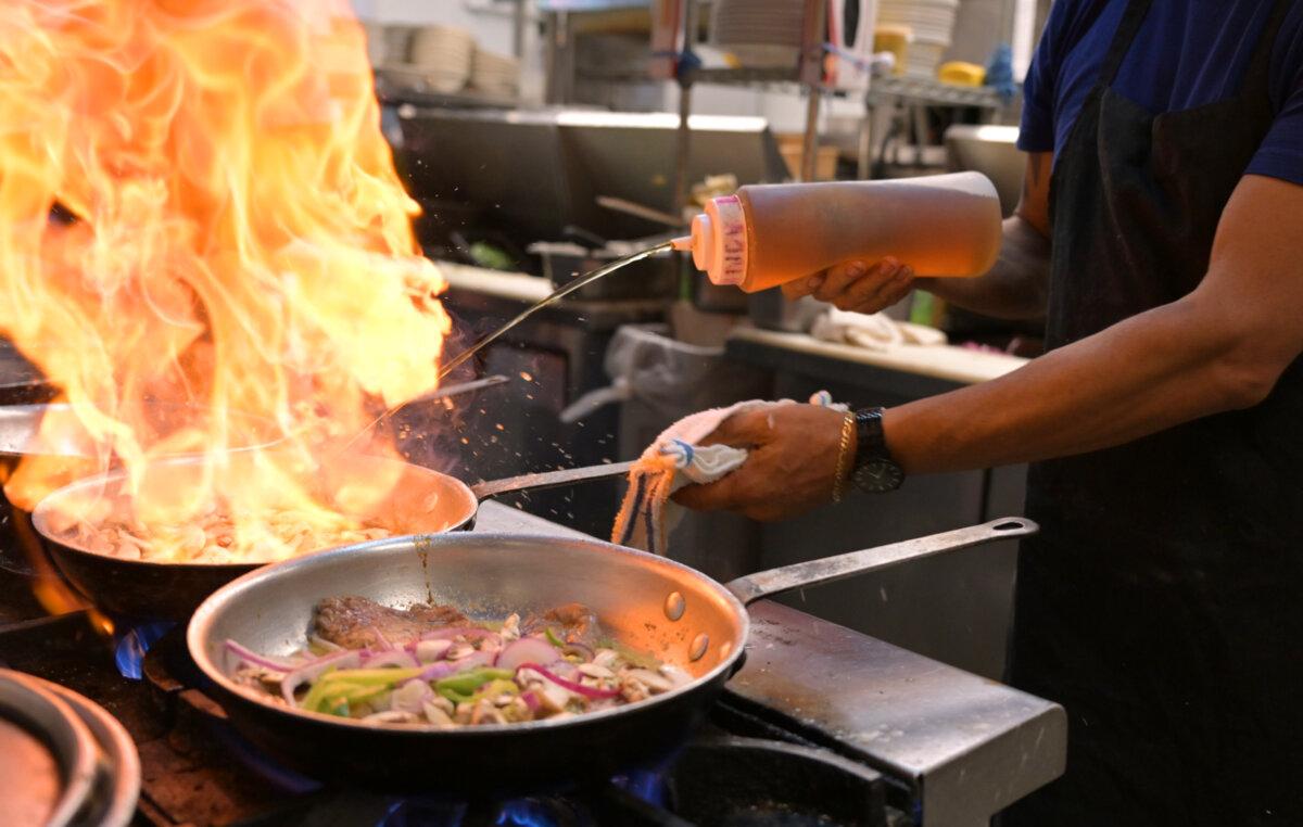 Jorge Labra, a cook at Cafe Jordano, jets cognac into a pan while preparing the Buffalo Royal on May 22, 2025. The dish—buffalo in a cream sauce with cognac and mushrooms—is one of five signature buffalo offerings at the restaurant in Lakewood. (RJ Sangosti/The Denver Post/TNS)