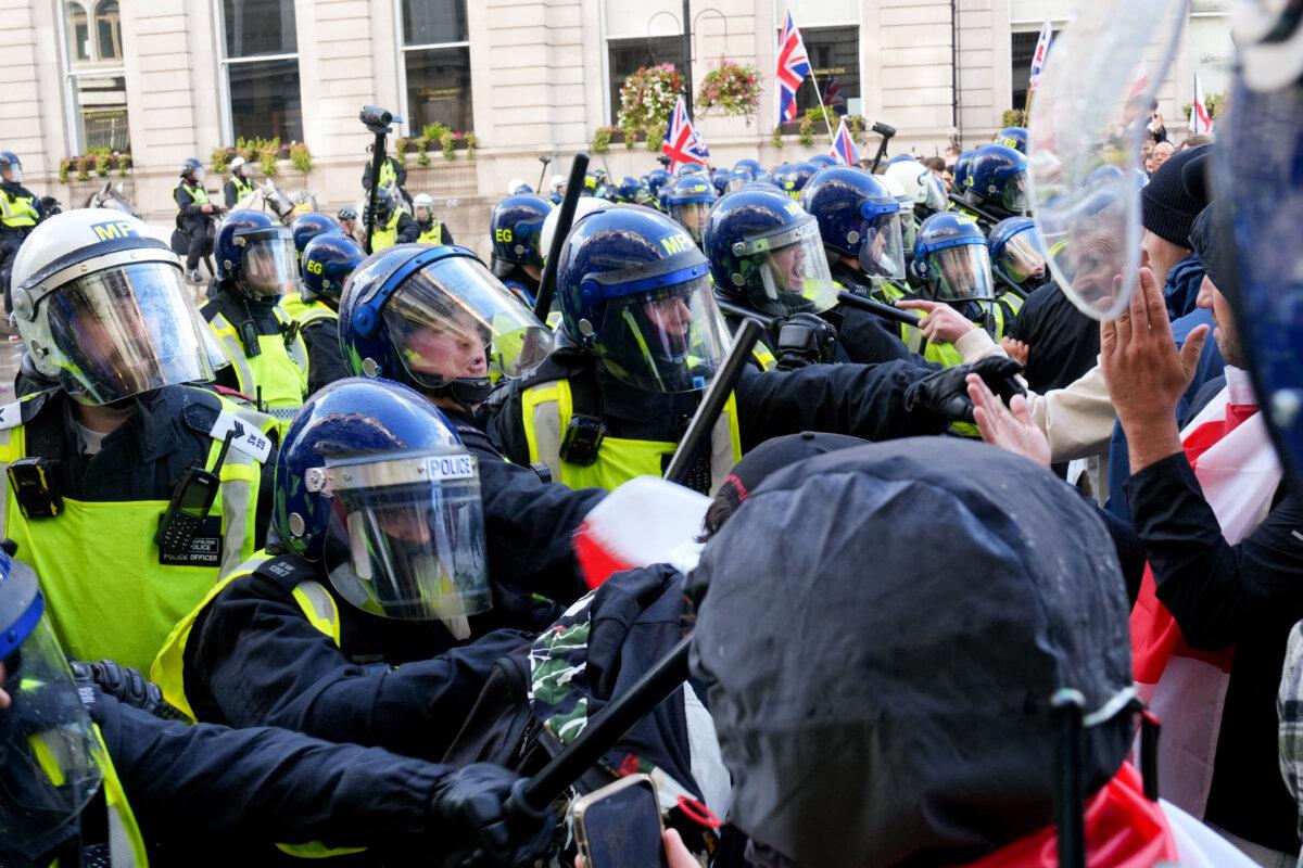 Police officers remonstrate with supporters of British activist Tommy Robinson during a march in central London, on Sept. 13, 2025. (Carlos Jasso/AFP via Getty Images)