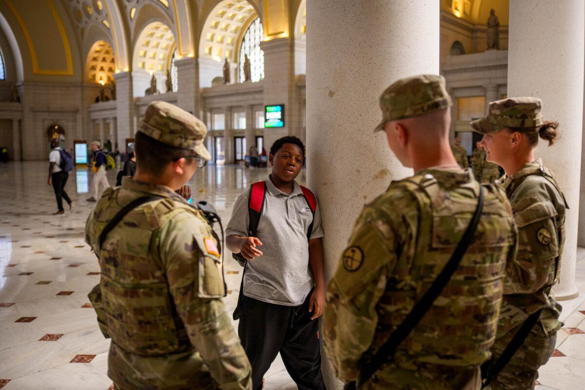 Trump Says He Will Declare National Emergency If Washington Stops Cooperating With ICE | USNN World News Members of the National Guard chat with young visitors to Union Station in Washington on Sept. 8, 2025. (Andrew Harnik/Getty Images)