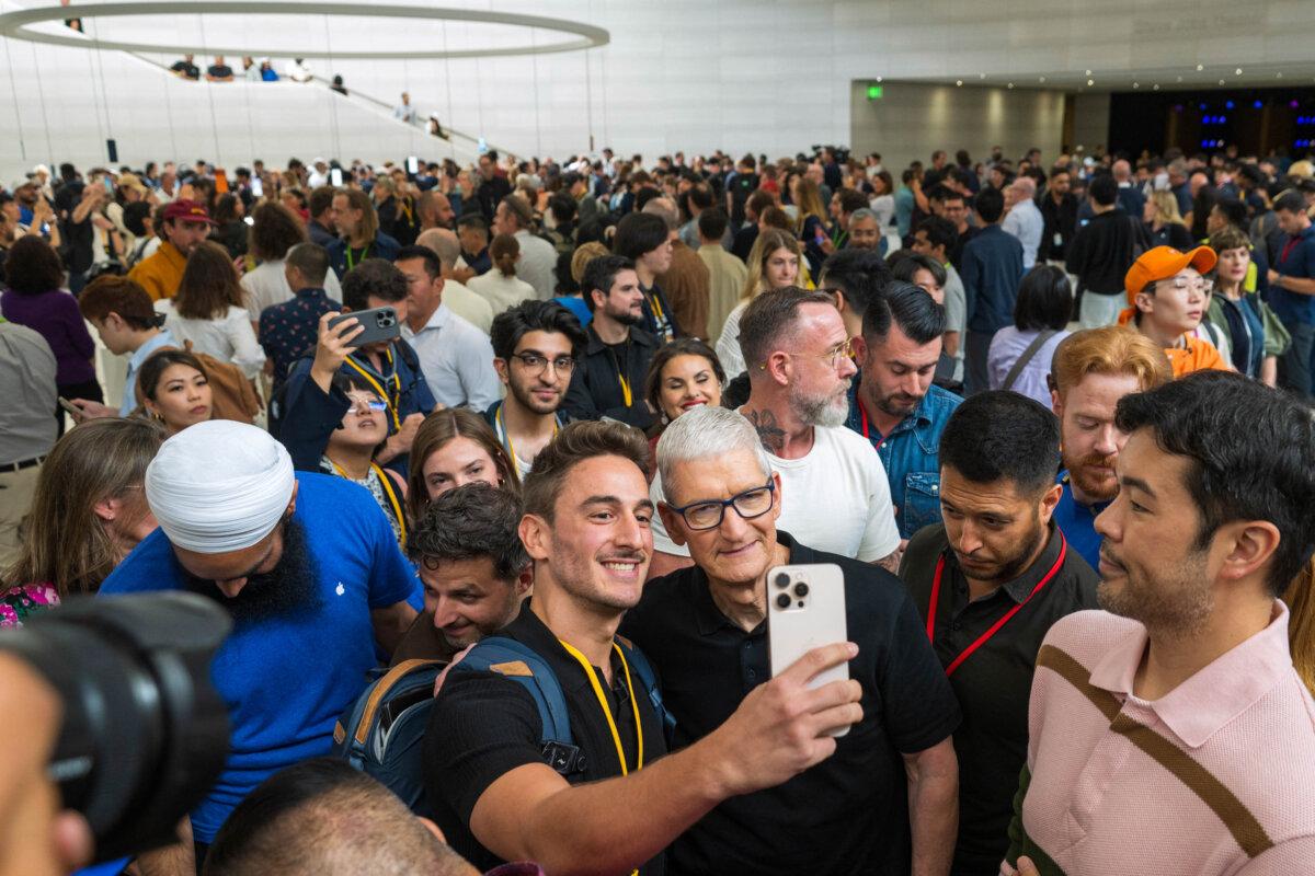 Apple CEO Tim Cook (C) poses for a selfie during Apple's "Awe-Dropping" event at the Steve Jobs Theater on the Apple Park campus in Cupertino, Calif., on Sept. 9, 2025. (Nic Coury/AFP via Getty Images)