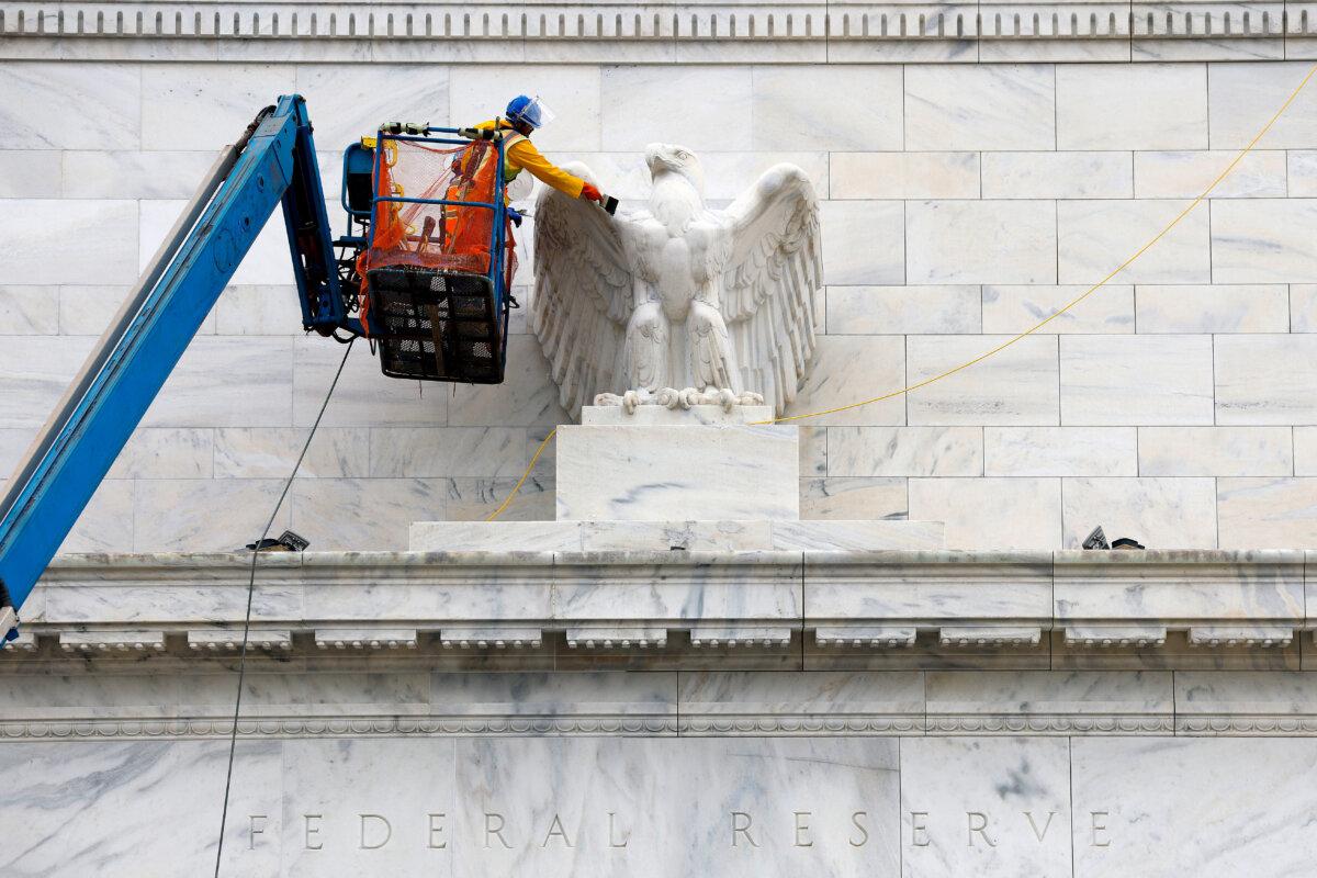 Workers clean and paint an eagle statue on the Marriner S. Eccles Federal Reserve Board Building, the main offices of the Board of Governors of the Federal Reserve System in Washington on Sept. 16, 2025. (Kevin Dietsch/Getty Images