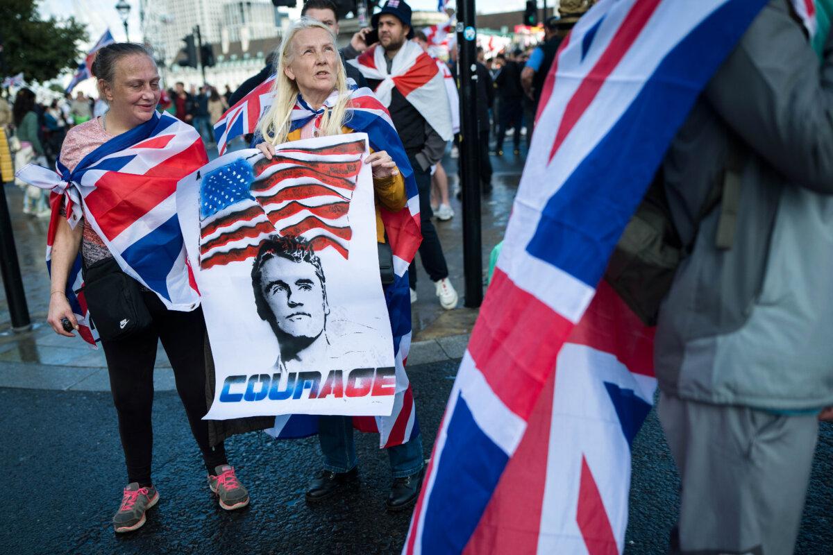 Vigils and Tributes for Charlie Kirk Span the Globe | USNN World News Protesters carry a poster depicting the late Charlie Kirk during the “Unite The Kingdom” rally on Westminster Bridge by the Houses of Parliament in London on Sept. 13, 2025. (Christopher Furlong/Getty Images)