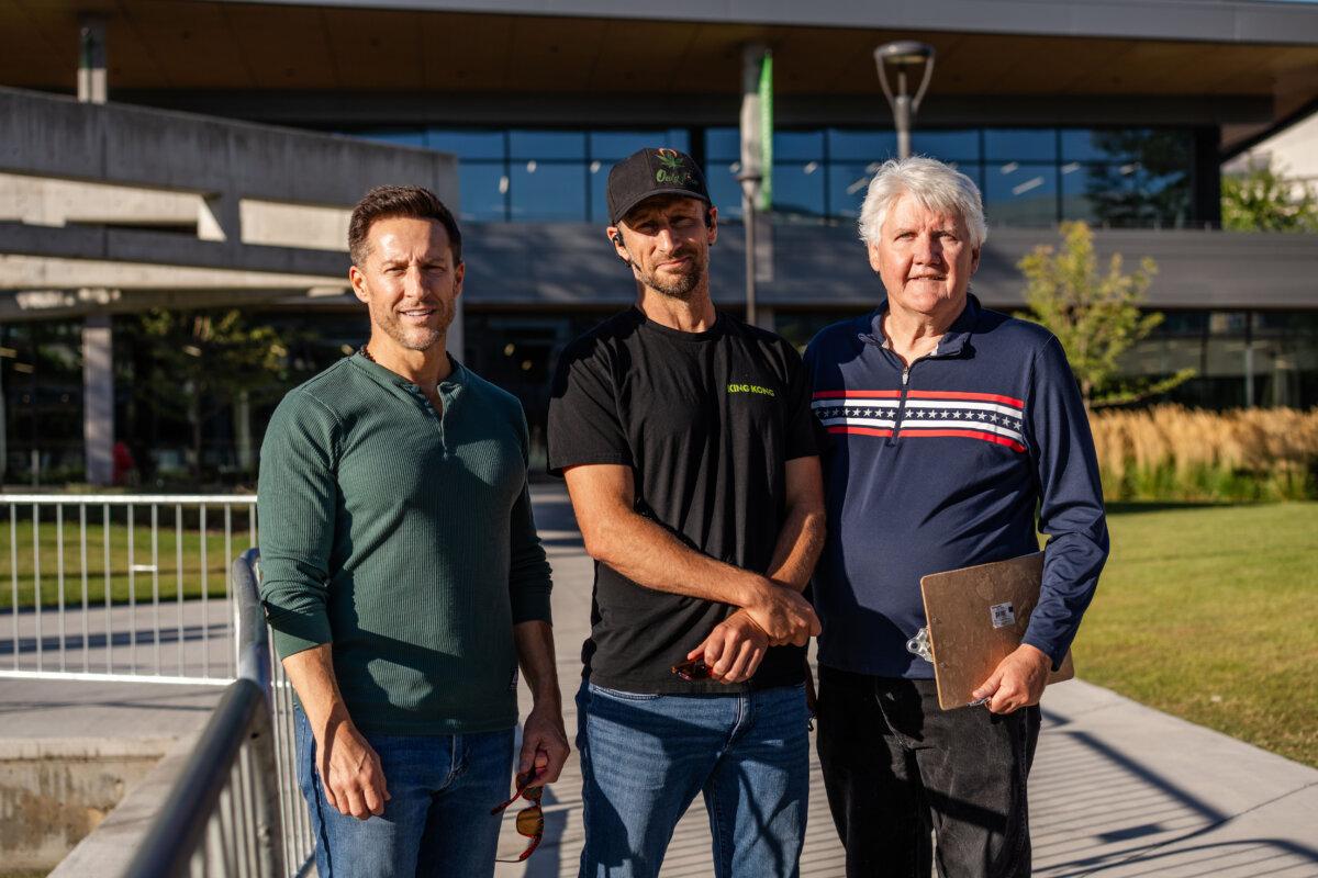 Honoring the memory of assassinated activist Charlie Kirk, Brandon Beckham (L) and his brother, Nathan Beckham (C), along with Val Johnson (R), meet at the site of the fatal shooting at Utah Valley University, in Orem, Utah, on Sept. 16, 2025. (Madalina Kilroy/The Epoch Times)