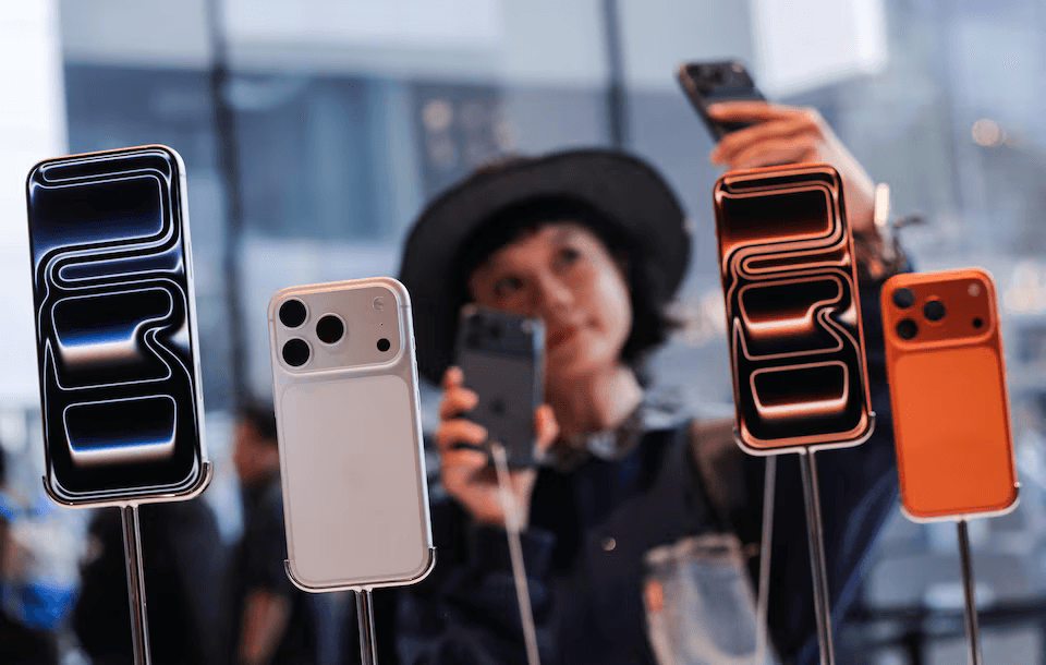 A woman takes a selfie with iPhones inside an Apple store as the new iPhone 17 series smartphones go on sale, in the Sanlitun area of Beijing on Sept. 19, 2025. (Maxim Shemetov /Reuters)