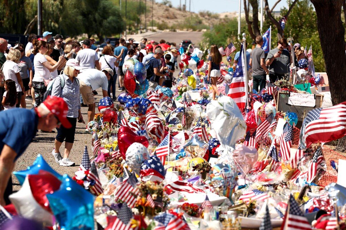 People gather at a makeshift memorial for Turning Point USA founder Charlie Kirk outside the organization's headquarters in Phoenix on Sept. 20, 2025. (Charly Triballeu/AFP via Getty Images)