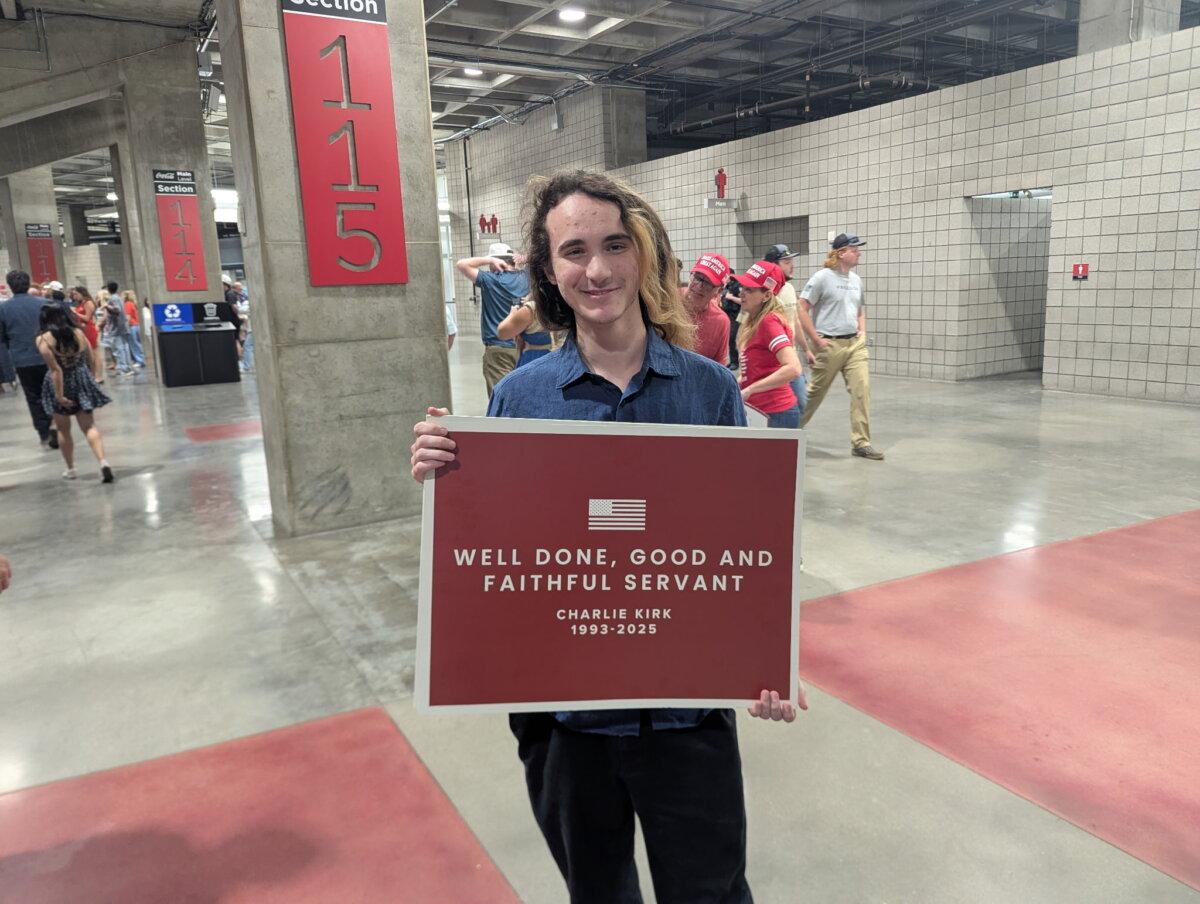 David Watz holds a poster reading “Well Done, Good and Faithful Servant” at Charlie Kirk’s memorial service at State Farm Stadium in Glendale, Ariz., on Sept. 21, 2025. (Ryan Morgan/The Epoch Times)