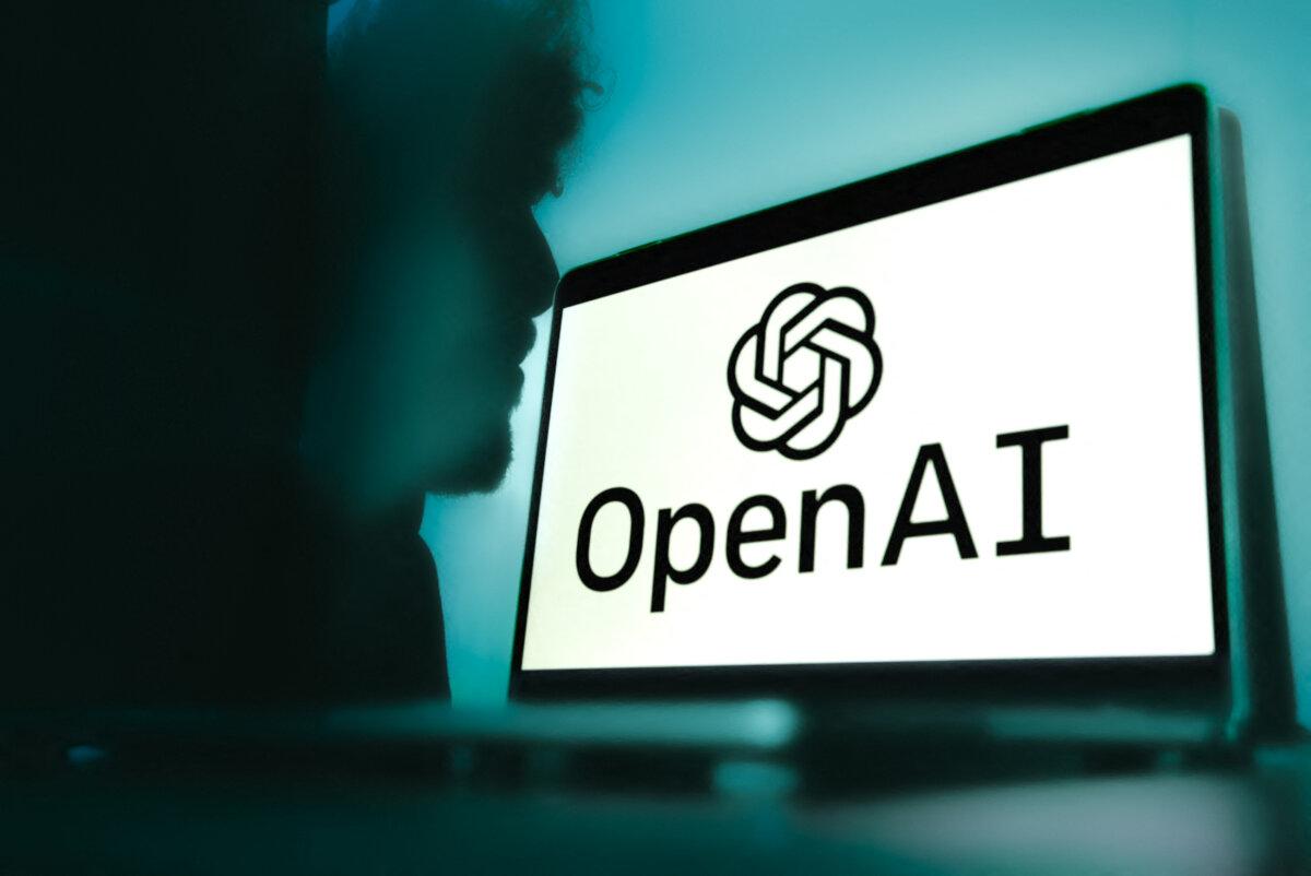 A computer with the Open AI logo is staged on a gradient blue background with the shadow of a man in the background in Grenoble, France, on Feb. 12, 2025. (Anouk Anglade/Hans Lucas/AFP via Getty Images)