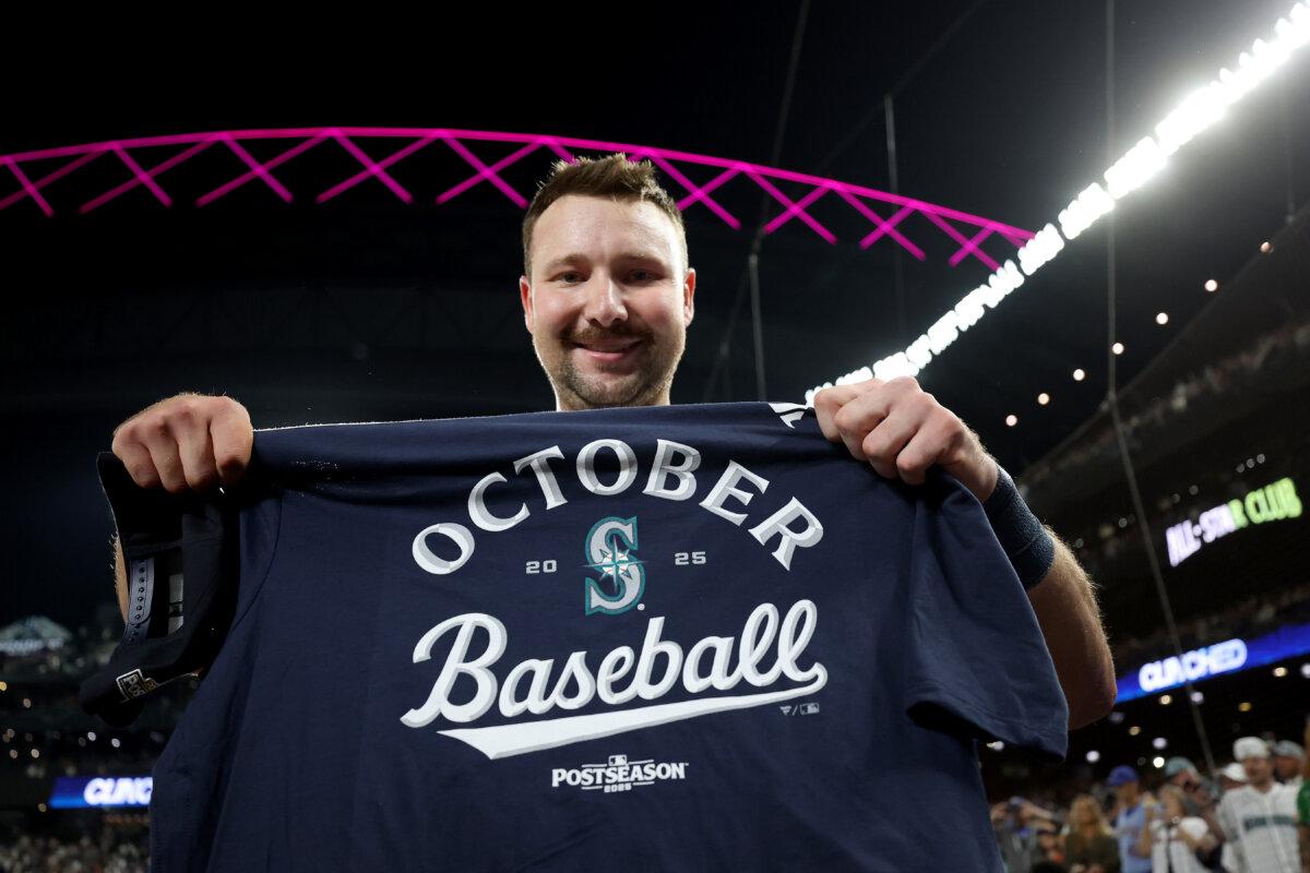 Cal Raleigh of the Seattle Mariners poses with a playoff shirt after clinching a playoff berth with the win against the Colorado Rockies at T-Mobile Park in Seattle, Wash., on Sept. 23, 2025. (Steph Chambers/Getty Images)