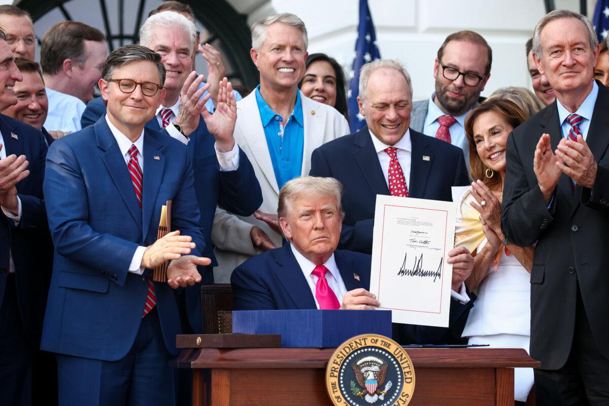 President Donald Trump, joined by Republican lawmakers, signs the One Big Beautiful Bill Act into law during an Independence Day military family picnic on the South Lawn of the White House on July 04, 2025. (Samuel Corum/Getty Images)