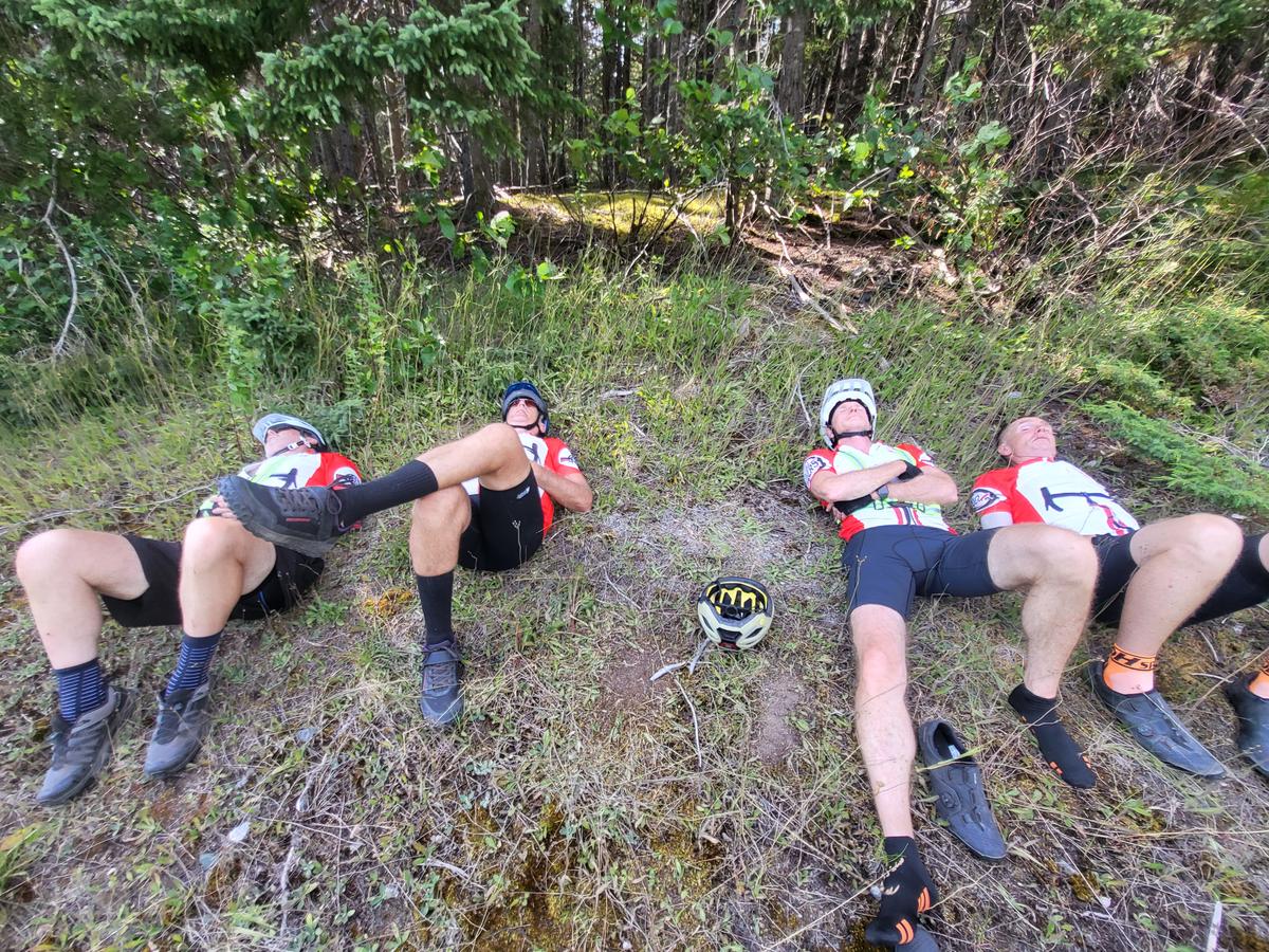 Lloyd Taylor (L) and his teammates take a breather while cycling through Howley, Newfoundland, on the eastern portion of the Spinning Wheels Tour in summer 2024. (Courtesy Spinning Wheels Tour)