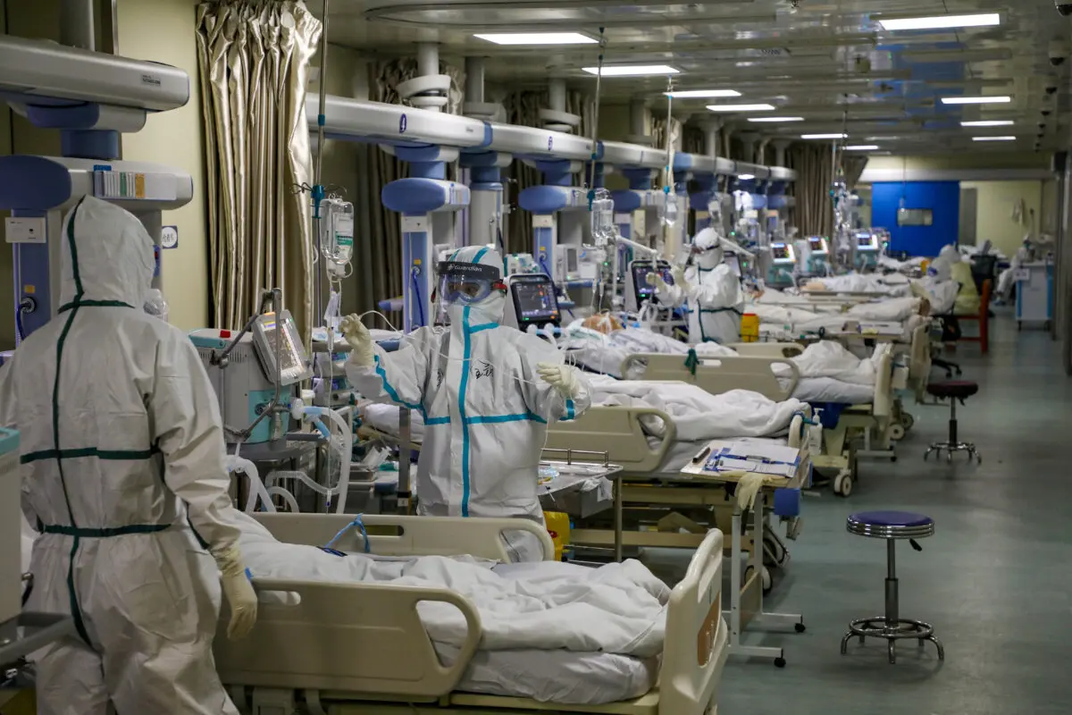 Medical workers in protective suits attend to COVID-19 patients at the intensive care unit (ICU) of a designated hospital during the coronavirus disease (COVID-19) outbreak in Wuhan, Hubei Province, China, on Feb. 6, 2020. (China Daily via Reuters)
