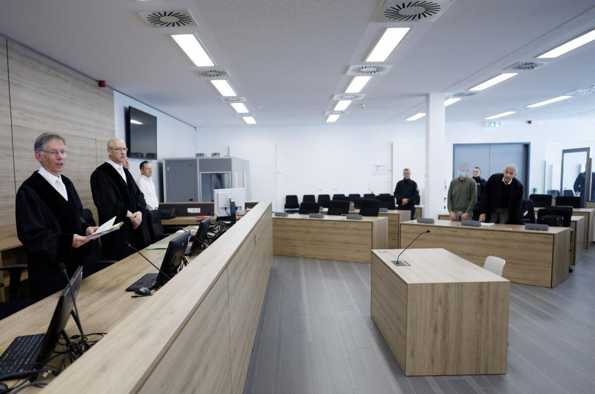 Judge Hans Schlueter-Staats (L) stands in the courtroom of the higher regional court in Dresden, Germany, on the last day of the high-profile espionage trial of two suspected spies for China, defendants Jian G (2nd R), a former assistant to then-member of the European Parliament Maximilian Krah, of the far-right Alternative for Germany party, and Yaqi X (unseen), accused of spying on German defense companies, on Sept. 30, 2025. (Odd Andersen/POOL/AFP via Getty Images)