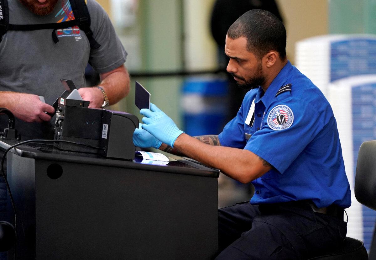 An employee with the Transportation Security Administration checks the documents of a traveler at Reagan National Airport in Washington on Jan. 6, 2019. (Joshua Roberts/Reuters)