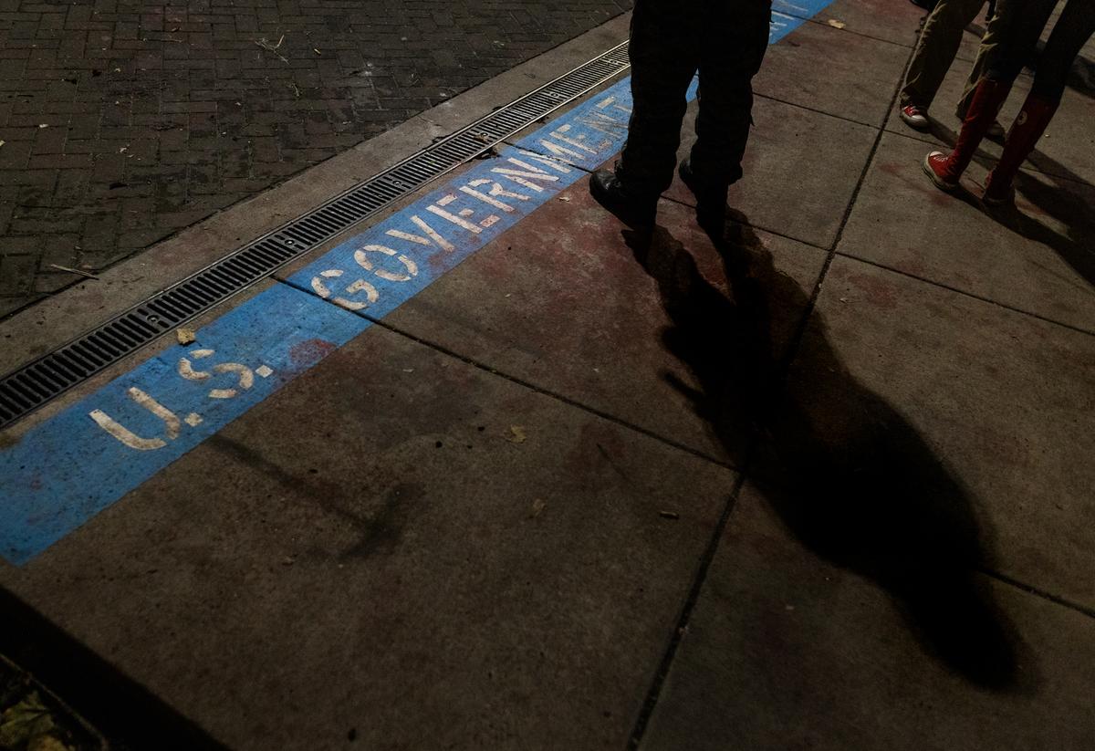 A line separates federal property from the sidewalk amid protests at Immigration and Customs Enforcement offices in Portland, Ore., on Oct. 3, 2025. (John Fredricks/The Epoch Times)
