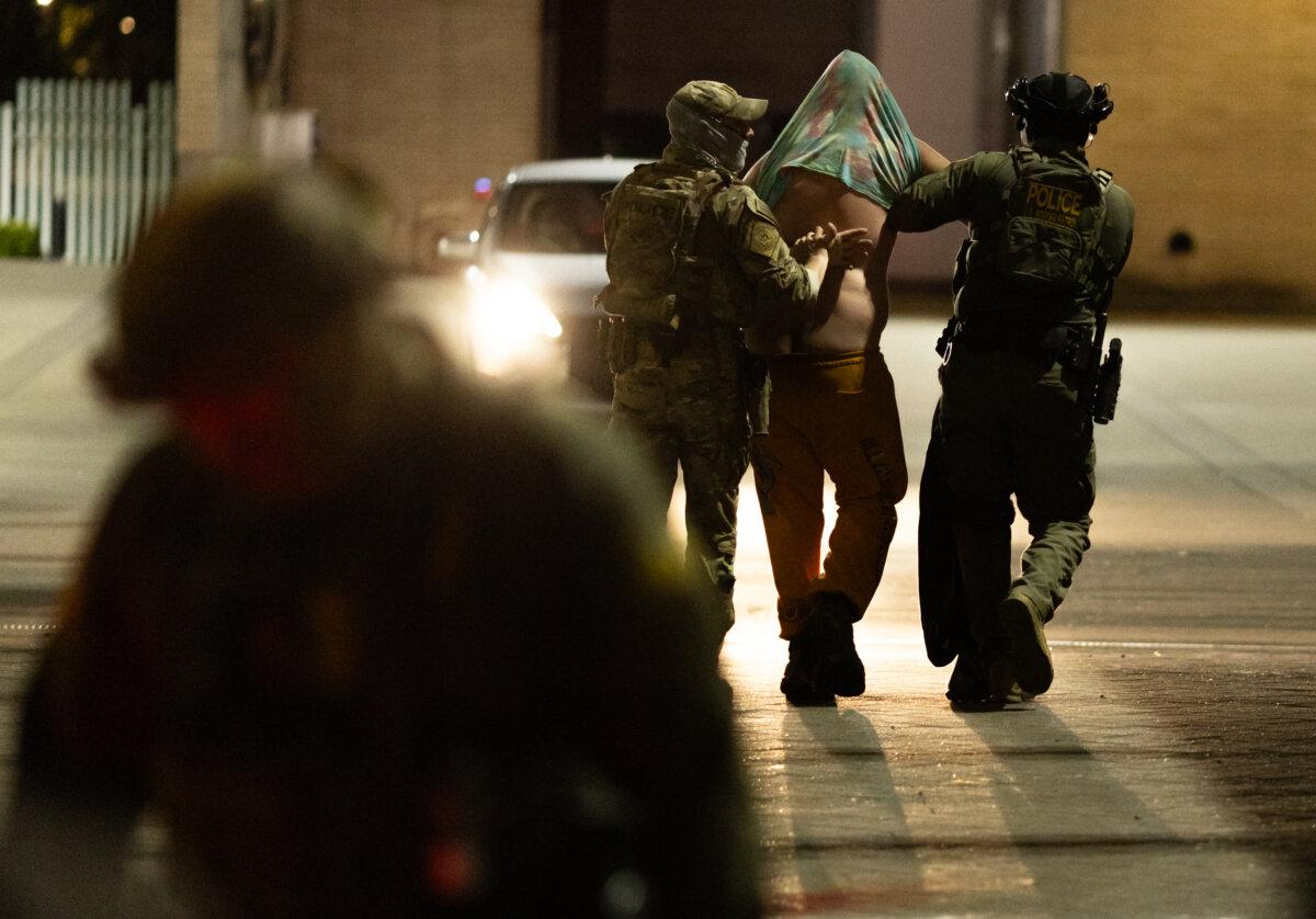 A protester is arrested in front of Immigration and Customs Enforcement offices in Portland, Ore., on Oct. 5, 2025. (John Fredricks/The Epoch Times)