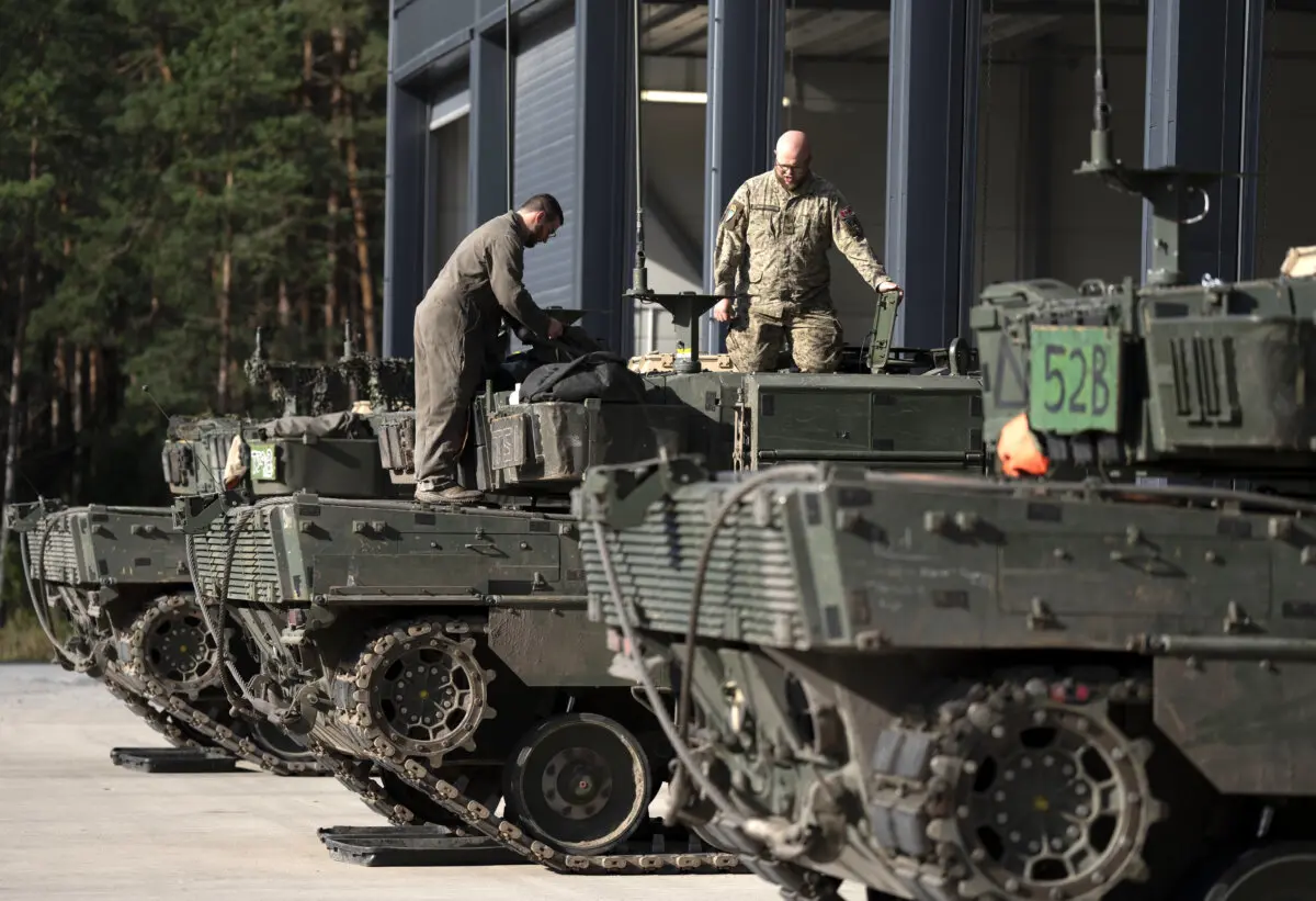 Members of the Canadian Armed Forces conduct maintenance on tanks at the Adazi Military base in Latvia on Aug. 27, 2025. (The Canadian Press/Christinne Muschi)