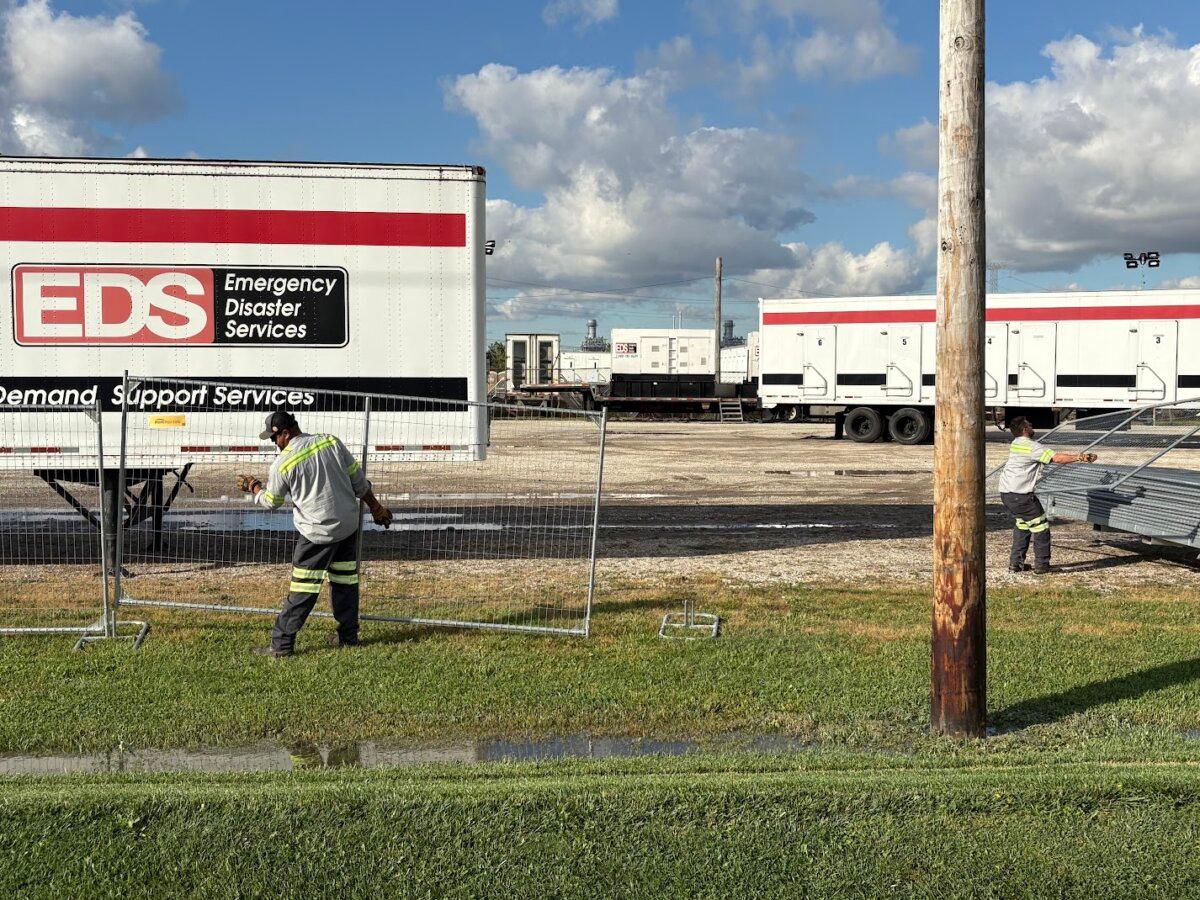 Workers install protective fencing outside an Army Reserve Training Center in Elwood, Ill. on Oct. 7, 2025. (Nathan Worcester/The Epoch Times)