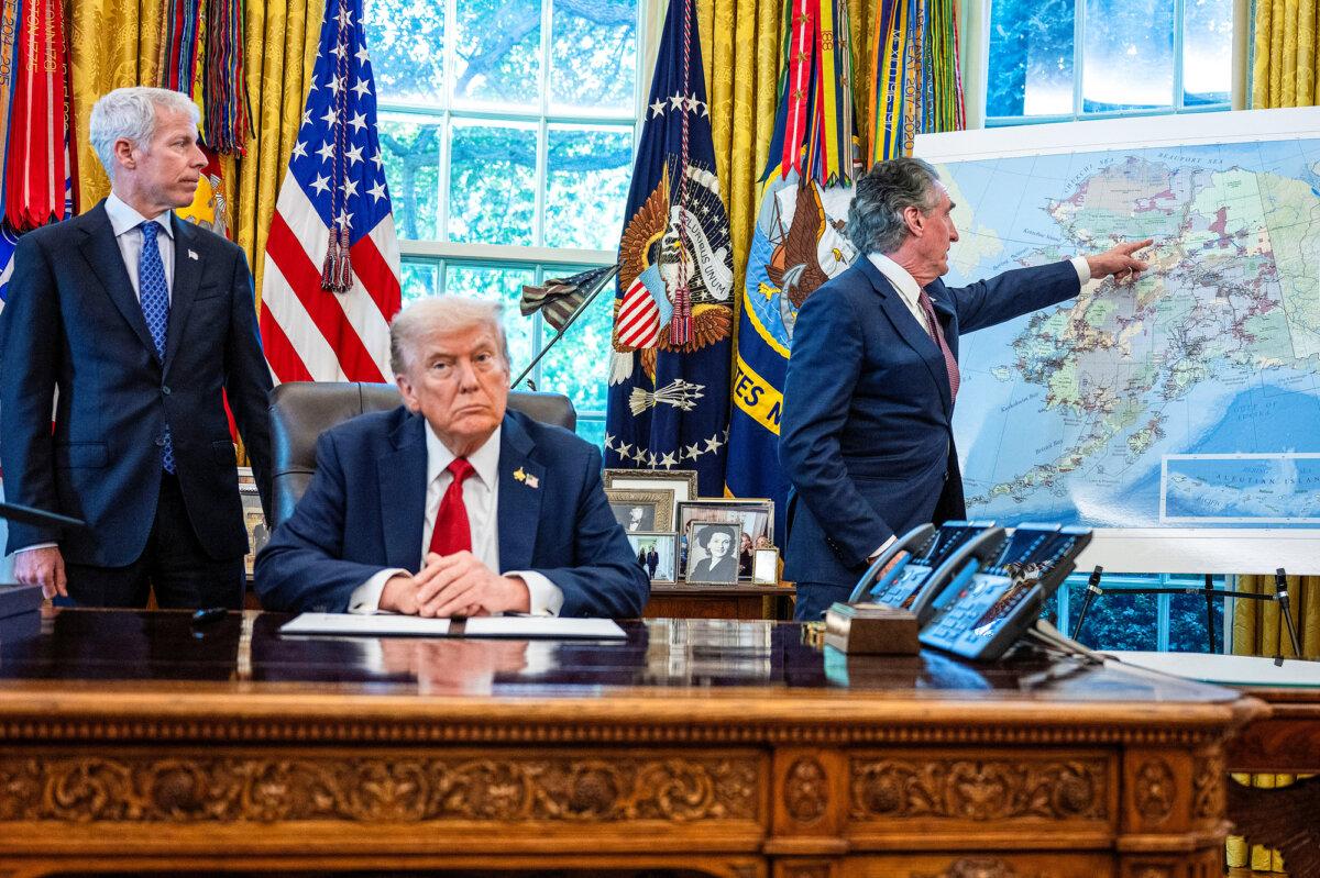 President Donald Trump listens as Interior Secretary Doug Burgum (R) points at a map of Alaska and Energy Secretary Chris Wright (L) looks on, after Trump signed an executive order to authorize the Ambler Road mining project in Alaska, in the Oval Office on Oct. 6, 2025. (Jim Watson/AFP via Getty Images)