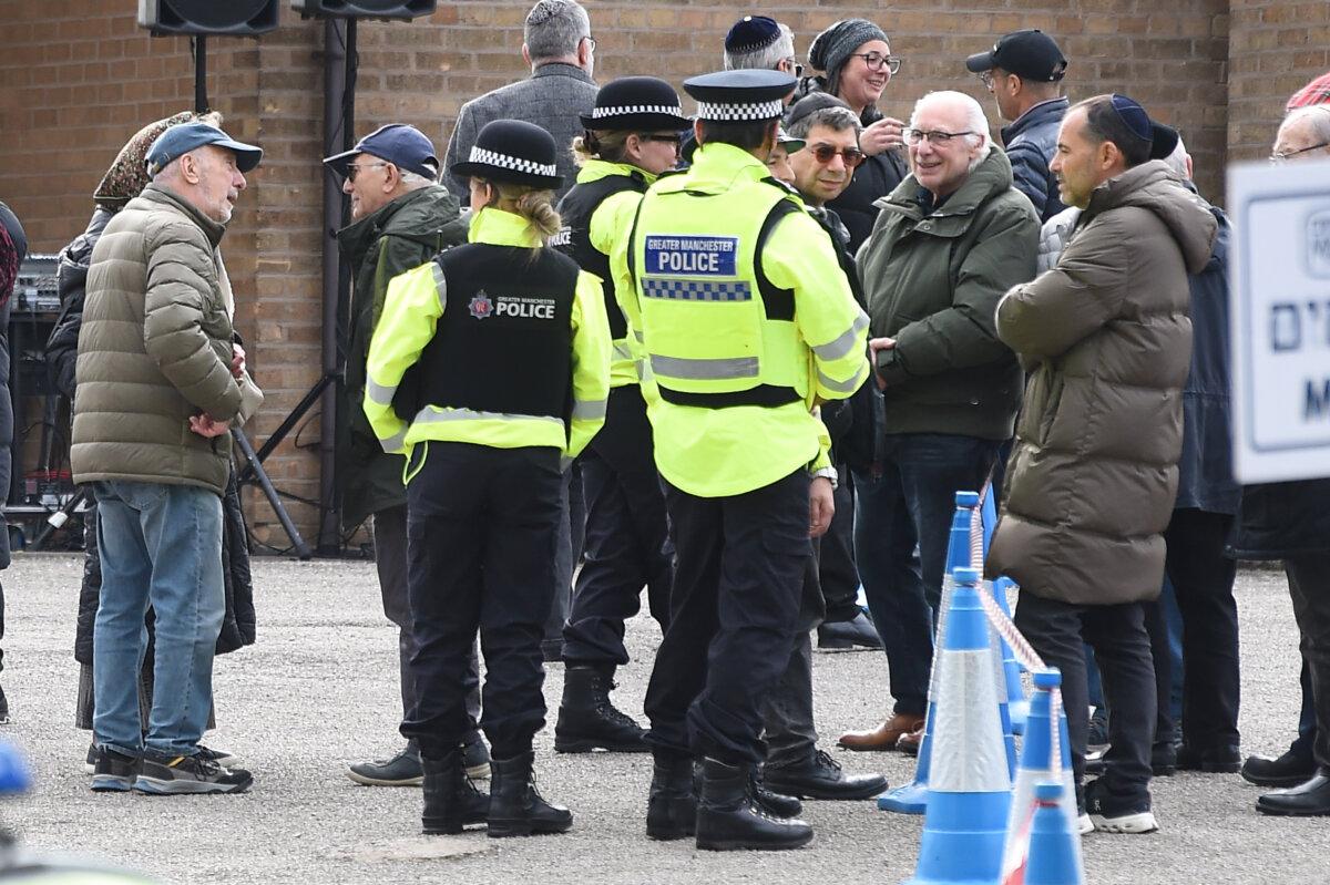 Police officers speak to mourners at the funeral of Adrian Daulby at Agecroft Jewish Cemetery in Salford, England, on Oct. 6, 2025. (Peter Powell/PA Wire)