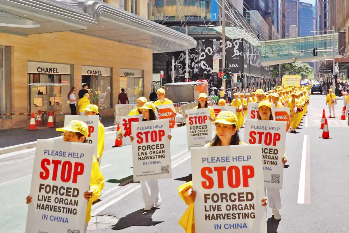 Falun Dafa practitioners holding signs to raise awareness about the brutal practice of organ harvesting conducted by the CCP, during a parade through the busy Sydney CBD in Australia, on Oct. 10, 2025. (Wang Nan/NTD TV)
