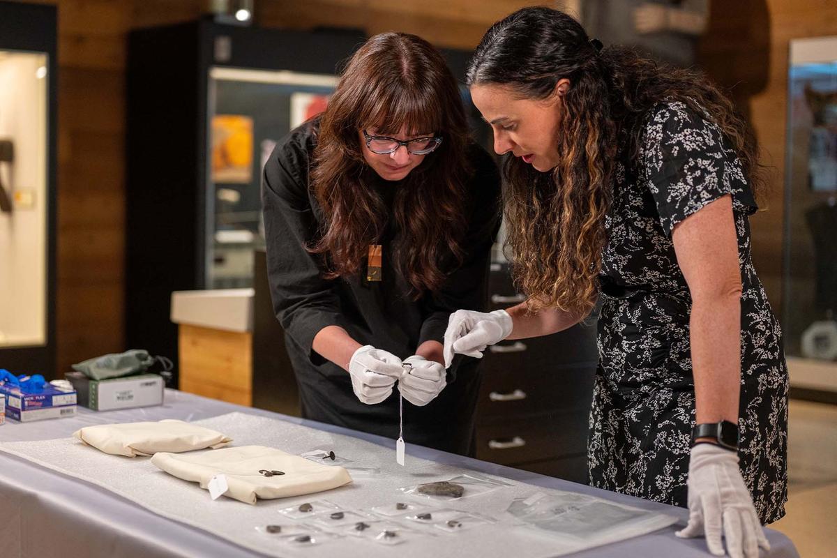 Sabrina Higgins and Barbara Hilden examine the artifacts believed to hail from medieval times that were found in a B.C. thrift store. (Courtesy of Simon Fraser University)