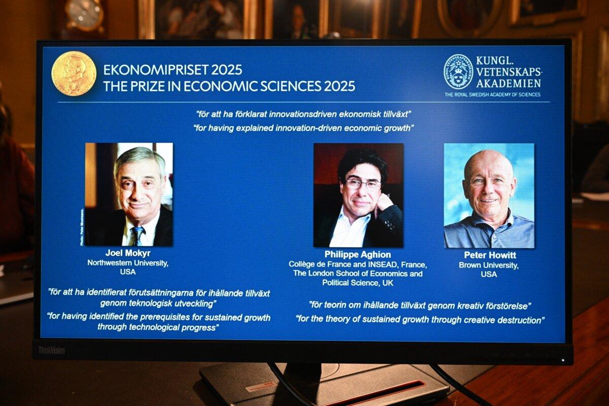 A screen displays the portraits of the 2025 prize winners (L-R) Joel Mokyr, Philippe Aghion, and Peter Howitt, during the announcement of the winners of the 2025 Nobel Memorial Prize in Economic Sciences at the Royal Swedish Academy of Sciences in Stockholm on Oct. 13, 2025. (Jonathan Nackstrand/AFP via Getty Images)