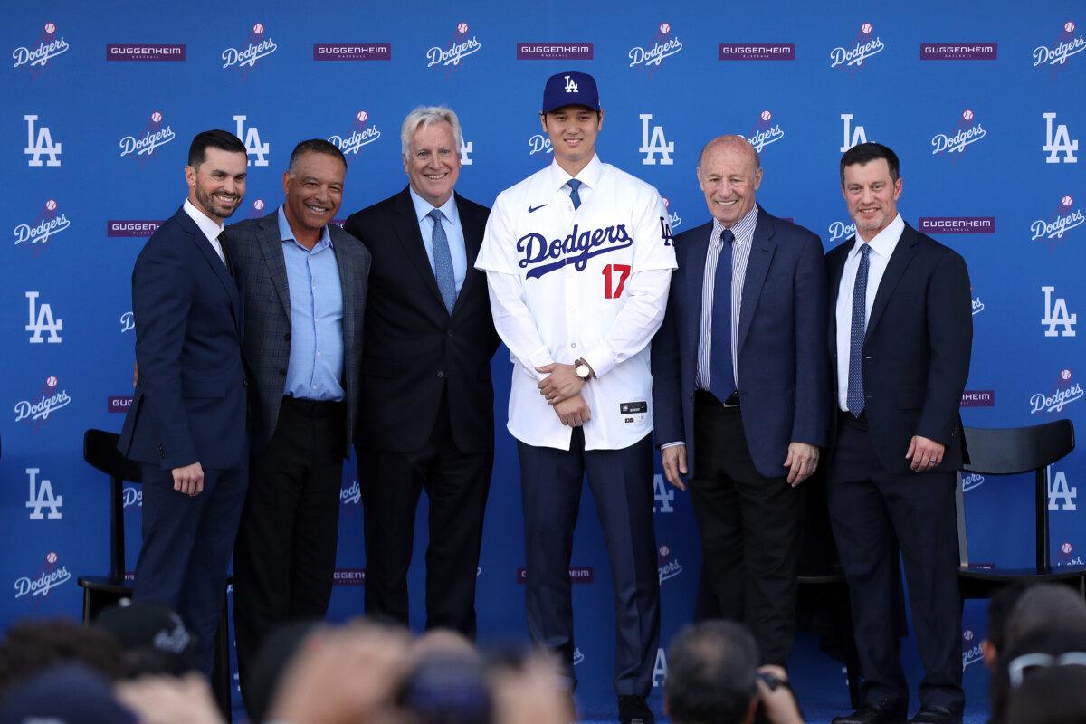 (L–R) General manager Brandon Gomes, manager Dave Roberts, owner and chairman Mark Walter, Shohei Ohtani, president and CEO Stan Kasten, and president of baseball operations Andrew Friedman pose for a photo at Dodger Stadium in Los Angeles, Calif., on Dec. 14, 2023. (Meg Oliphant/Getty Images)