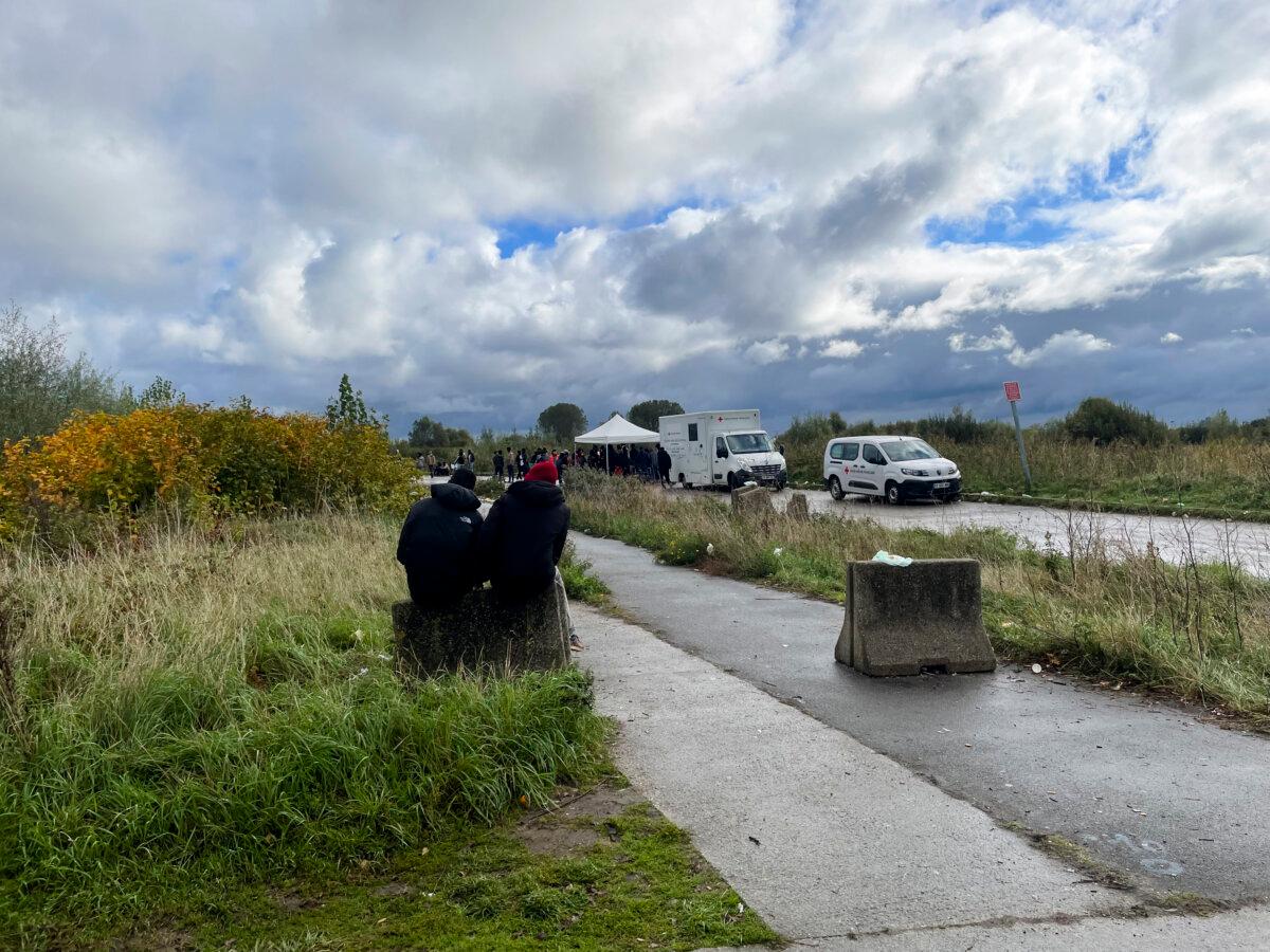 Britain Turns to Old Army Barracks to House Asylum Seekers as Hotel Costs Spiral | USNN World News Immigrants sit outside a Red Cross food bank in Calais, France, on Oct. 15, 2025. (Owen Evans /The Epoch Times)