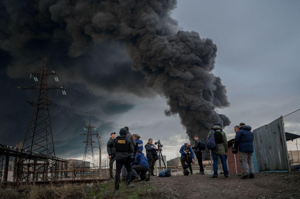 Journalists and residents stand as smoke rises after an attack by Russian army in Odessa, on April 3, 2022. (Bulent Kilic/AFP via Getty Images)